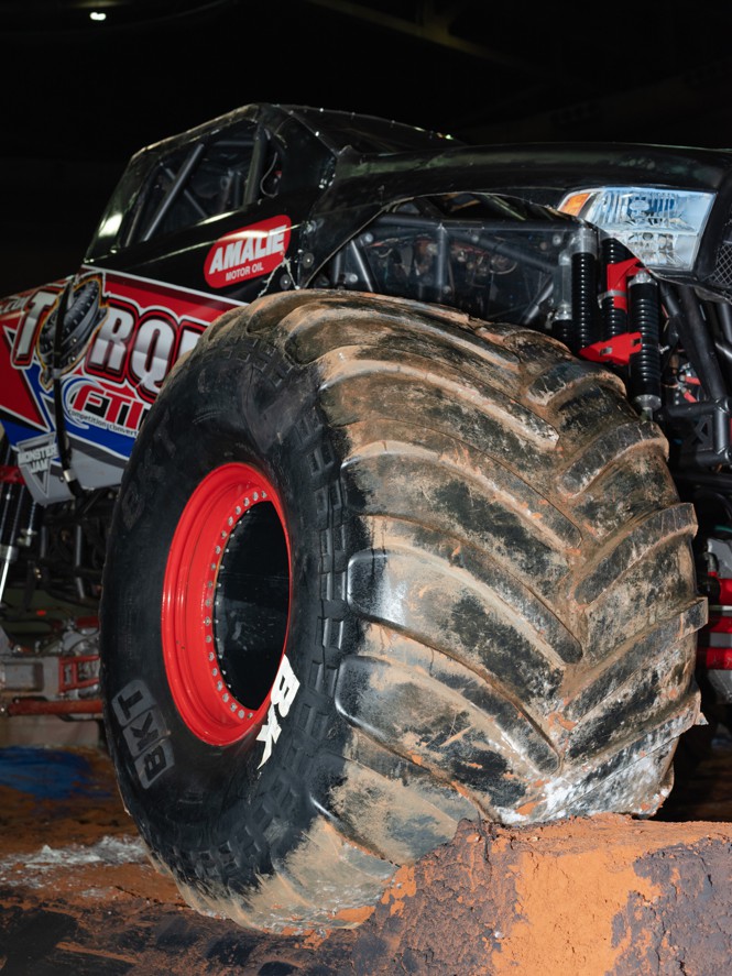 Monster truck tires on a dirt mound.