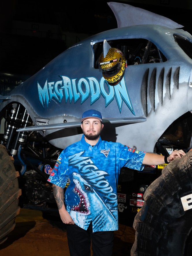 Driver Tristan England poses in front of the monster truck Megalodon.
