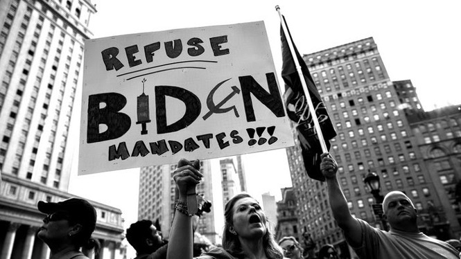 A black and white photo of protestors holding an anti-mandate sign