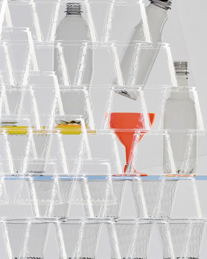 Plastic cups stacked with bottles behind them