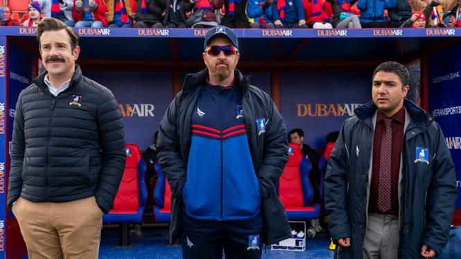 Three coaches standing in a stadium in 'Ted Lasso'
