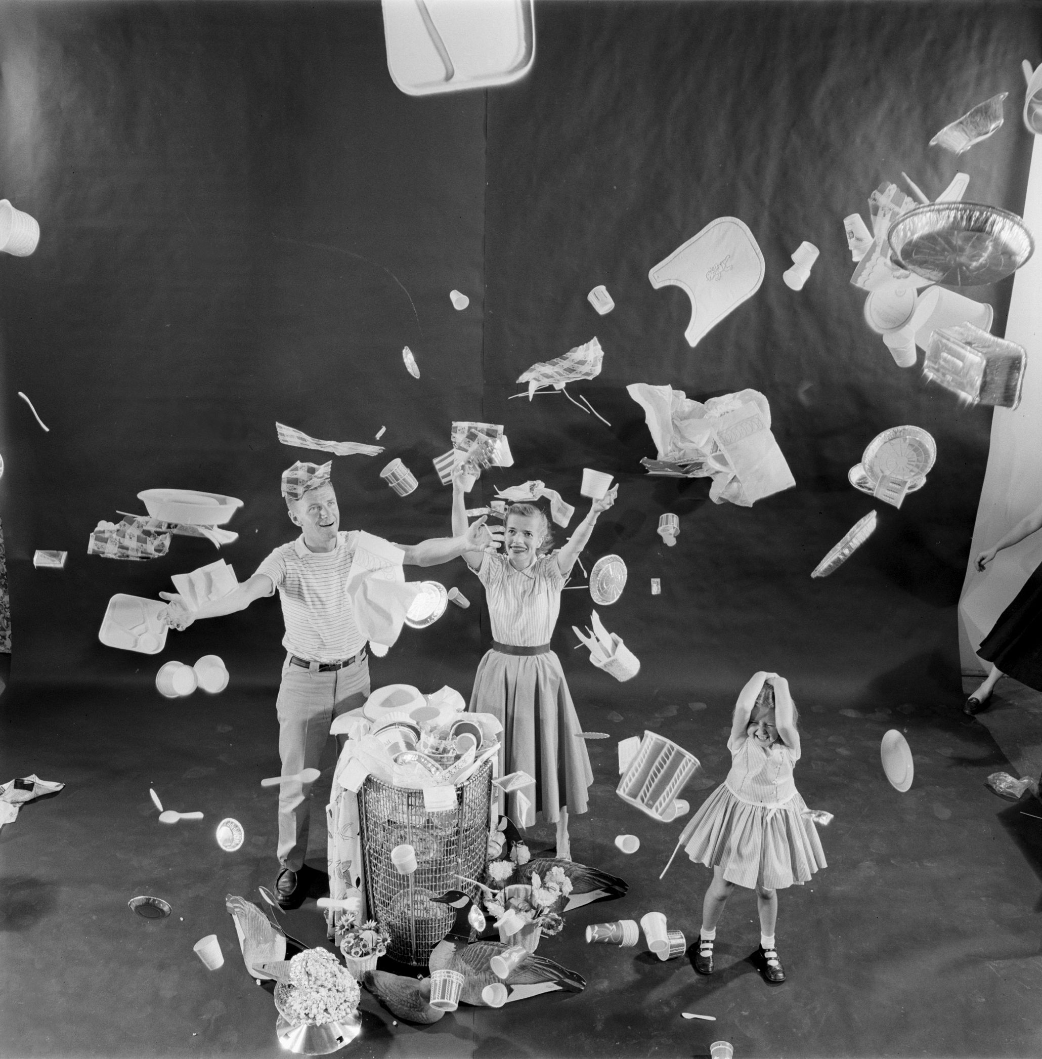 family throwing plates plastic and paper throw away items into the air