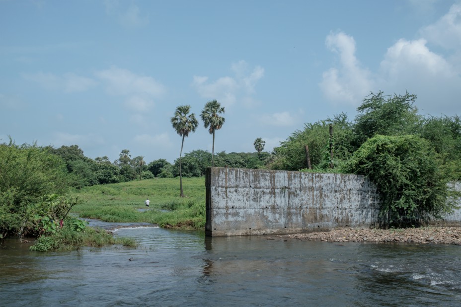 A concrete fence lines Mithi river.