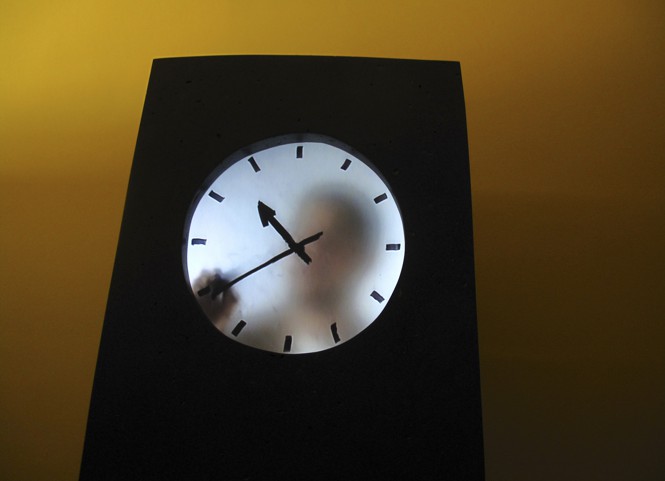 Man stands behind a semi-translucent clock