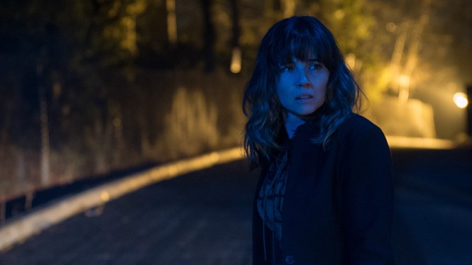 Linda Cardellini standing on a dark road, in "Dead to Me"