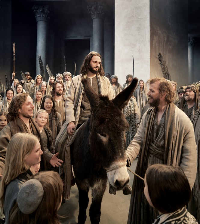 Jesus in passion play riding on a donkey.