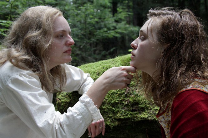 Elisabeth Moss holds another woman's chin and stares at her in "Shirley"