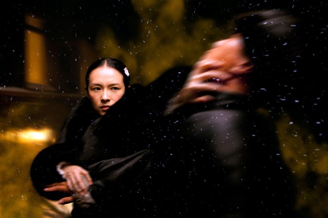 A young woman fights a blurred figure in 