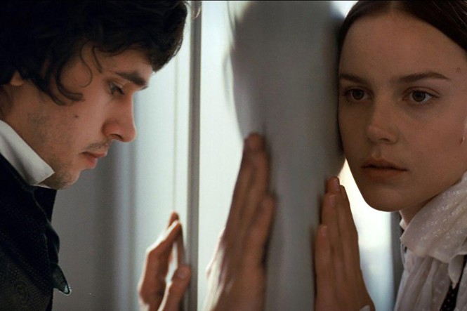 A man and a woman lean into opposite sides of a door, facing each other in 