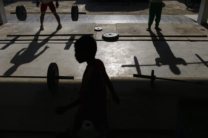 Silhouettes of boys lifting weights