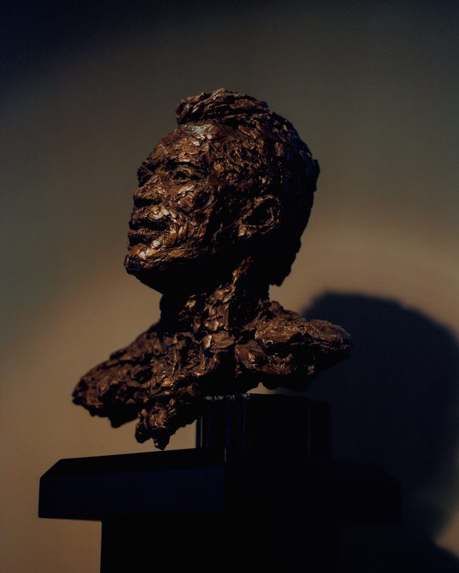 Foto af skulptur af Schwarzeneggers hoved og skuldre i bronze mod mørk baggrund