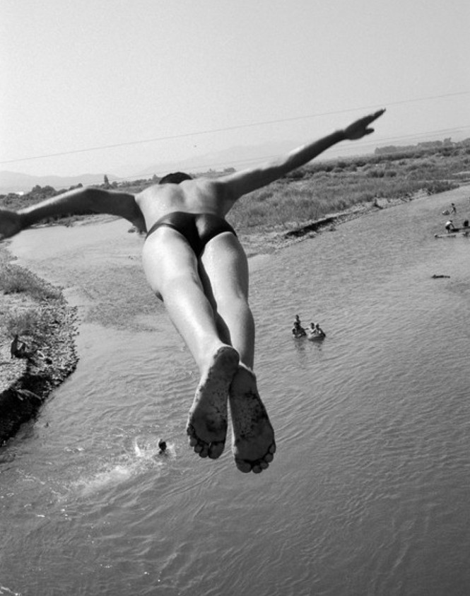 A person wearing a swimsuit jumps into the sea