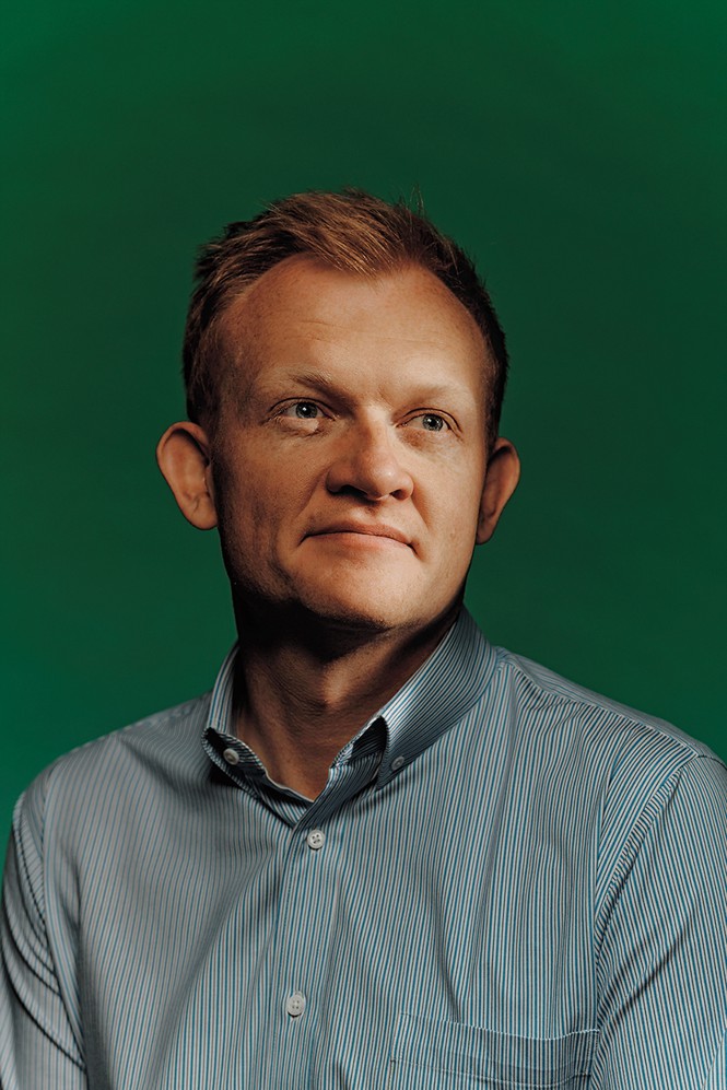 photo of man in collared shirt against green background