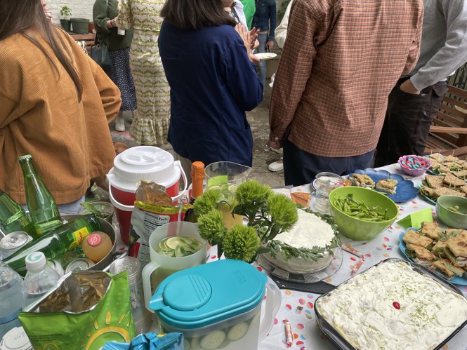A table full of party snacks—peas, green Sun Chips, gummy worms, green finger sandwiches, a cake with a crown of parsley.