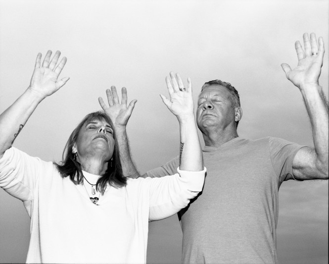 two people with hands raised to the sky