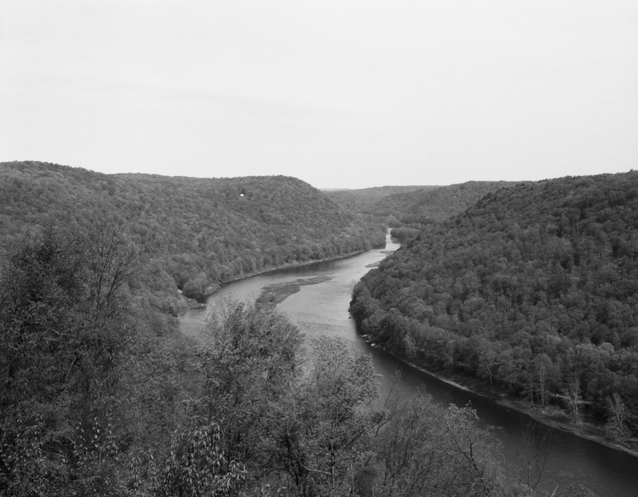 BW image of a winding river surrounded by low mountains