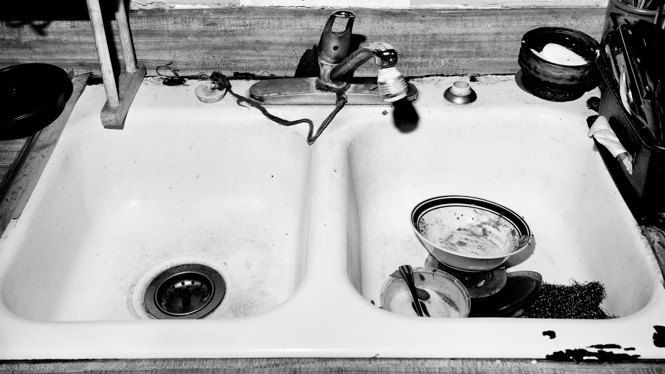 A black and white image of a sink with bowls in it