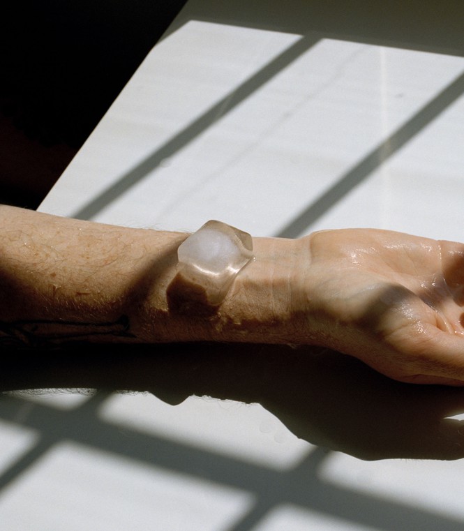 a man's wrist with an ice cube melting on it in the sunlight