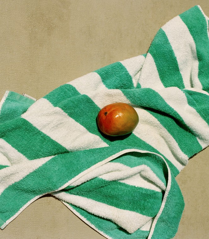 a green and white striped towel with a mango