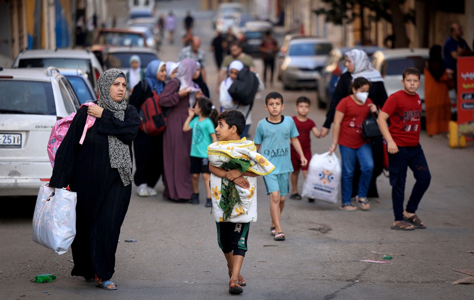 Picture of Palestinians carrying their belongings fleeing to safer areas in Gaza City after Israeli air strikes.