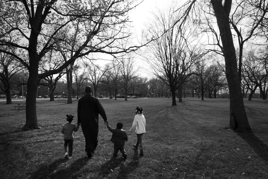 Single father Mike Harvey, 38, and his children, Siddeeqa, 6, Nadia, 4, Yasin, 2 walk in a field at Blackhawk apartment complex April 22, 2007  in Rockford, Illinois. Harvery, born in Rockford, has lived in Chicago and Atlanta, GA, moved back to his mothers one-bed apartment with three of his five children in Jan 2007 after divorce with his wife. Harvey works at Chysler factory as temporary worker.  (Photo by Kuni Takahashi/Getty Images)