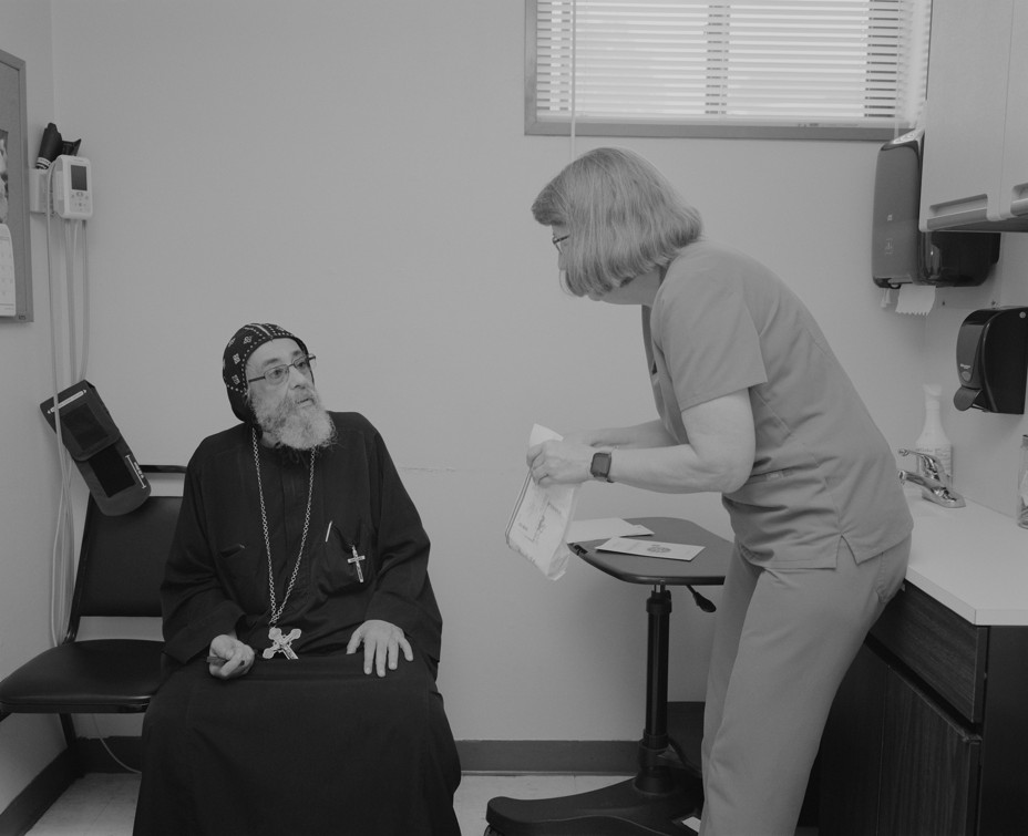 Picture of Marilyn Metzler, RN interacting with Father Markorieos Ava Mina at CrossOver Healthcare Ministry in Richmond, Virginia.