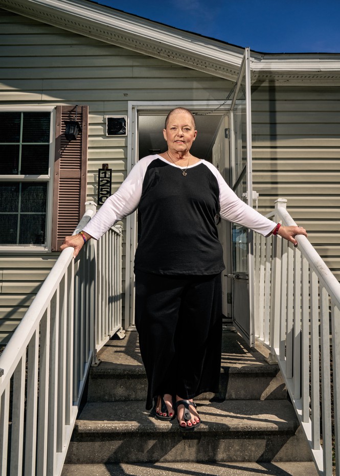photo of woman standing on stairs outside home with hands on railings