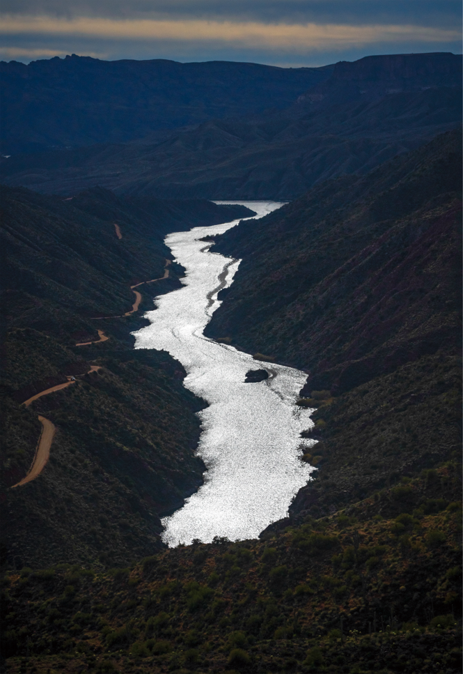 photo of aerial view of valley at dawn or dusk with light reflecting off the river running through it