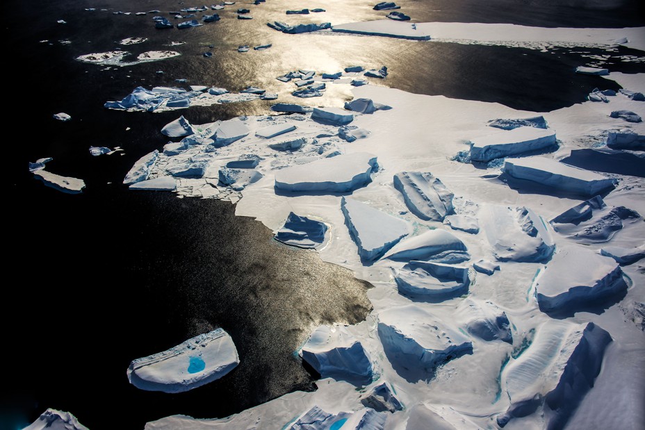 photo of massive jagged blocks of ice near shore, some frozen in place