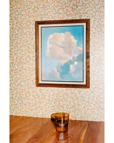 A cup on a table in front of a painting