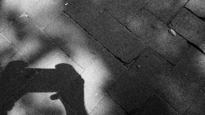 A shadow of somebody holding a phone