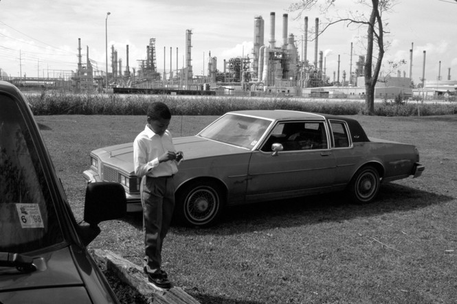 black and white image of a boy standing in front of chemical refinery plants in Baton Rouge, Louisiana