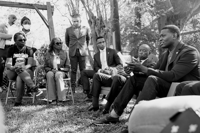 black and white image of Michael Regan talking with community members in Houston, Texas