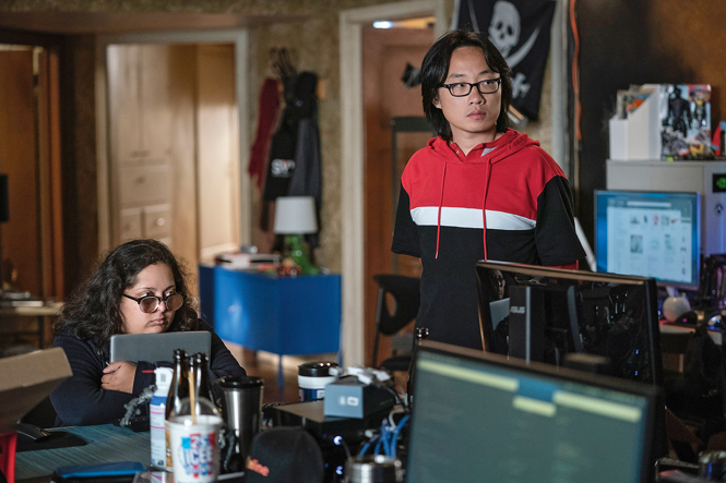 still from "Silicon Valley" with Yang standing in glasses and hoodie behind multiple computer monitors