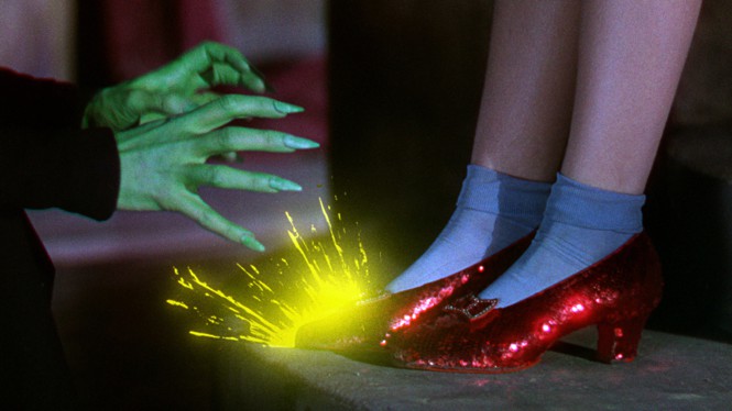 The green hands of the Wicked Witch of the West spark against Dorothy's ruby red slippers