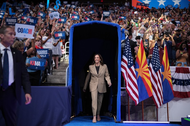 Kamala Harris walks out of a tunnel at a rally.