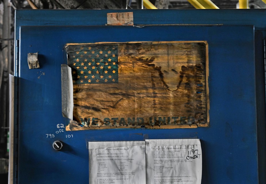 An American flag printed on a torn piece of paper is taped to a blue cabinet