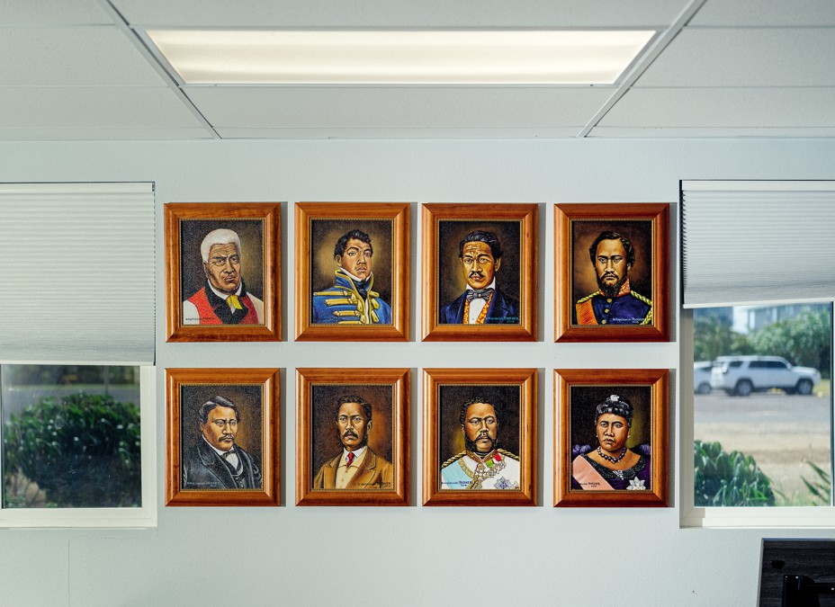 photo of wall of 8 framed portraits of people in period dress, in 2 rows of 4 each, between windows