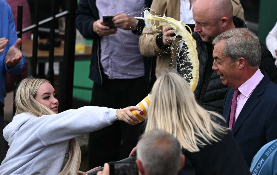 A person throws a milkshake in the face of Nigel Farage, the newly appointed leader of Britain's right-wing populist party, Reform UK, and the party's parliamentary candidate for Clacton, during his election campaign launch in Clacton-on-Sea, England, on June 4, 2024. The thrower, Victoria Thomas Bowen, was later charged with assault. #