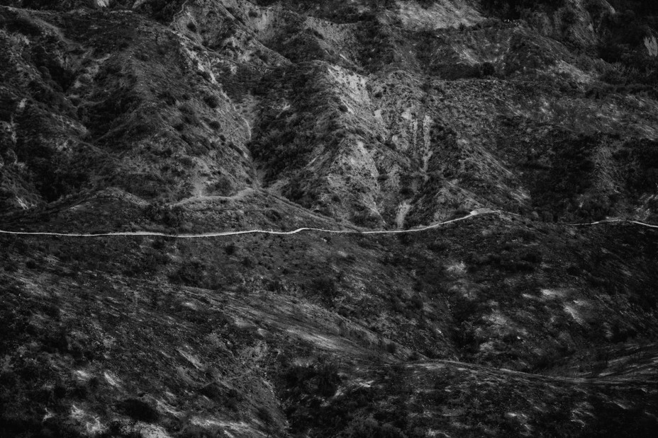 In a black and white image there is a trail going horizontally