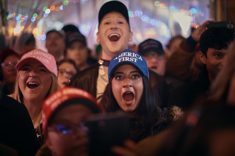 A group of people at a bar smile and shout