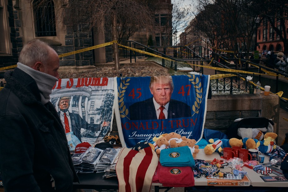 A man walks past a table full of Donald Trump merchandise 