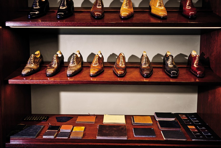 photo of two shelves of sample men's shoes in different leathers with an array of swatches beneath