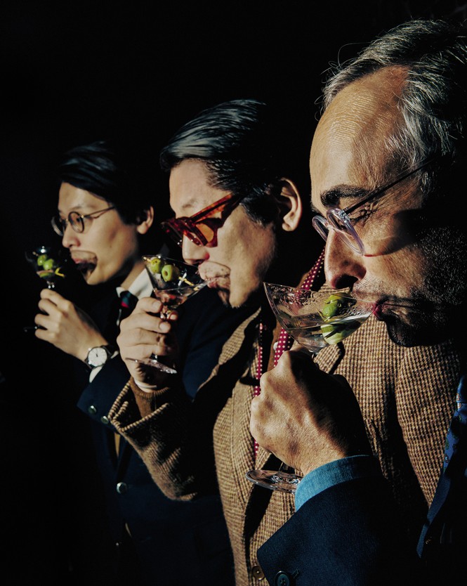 photo of 3 men in a row each raising a martini glass to his mouth for a sip