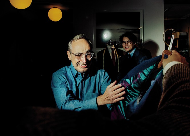 photo of Gary beaming and holding the lining of the suit jacket