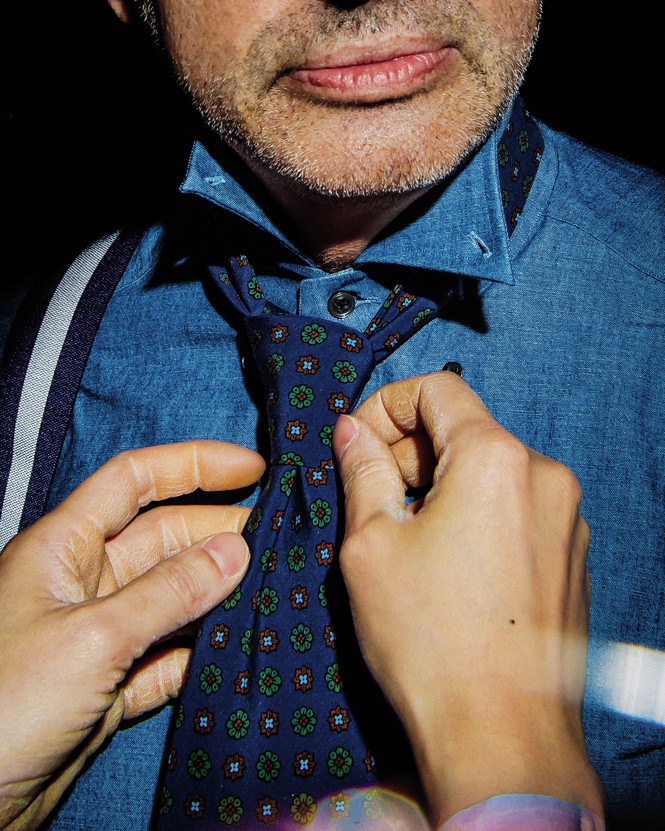 photo of man tying dark blue tie for the author