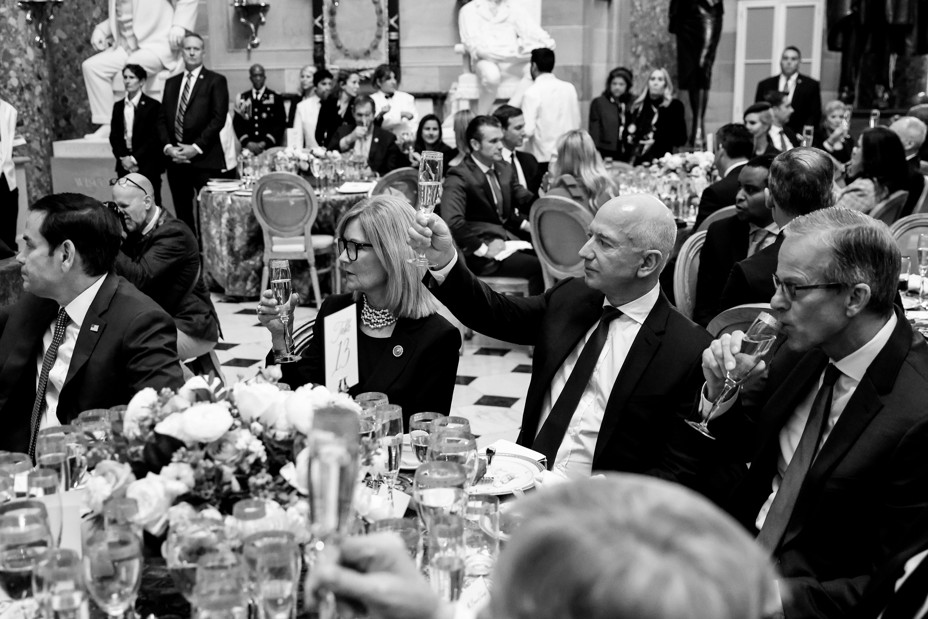 In a black and white photo, Jeff Bezos sits with politicians at a luncheon