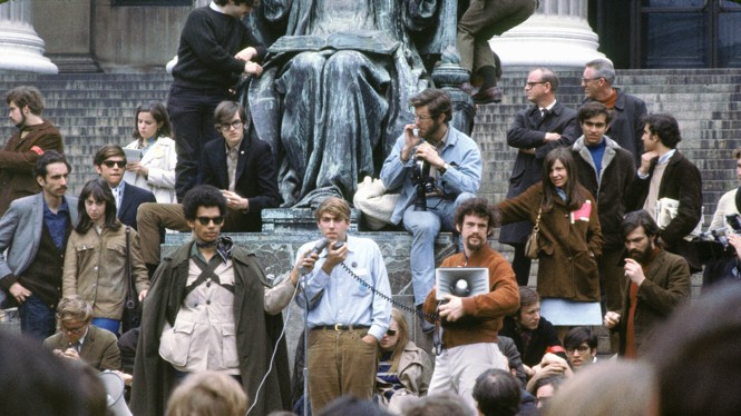 a crowd surrounds a statue 