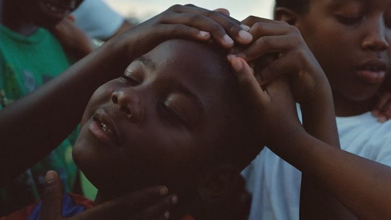 Three young boys tenderly holding one another