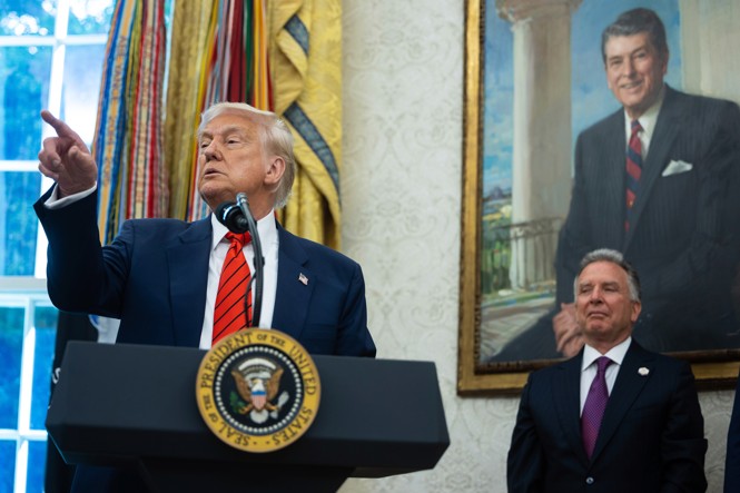 Donald Trump speaks at a podium in the oval office while Steve Witkoff stands behind him